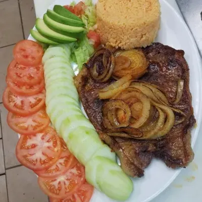 Grilled steak with onions, sliced tomato, cucumber, avocado and rice